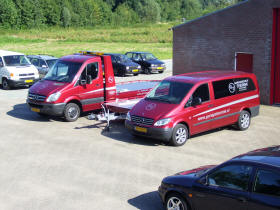De auto-ambulance en twee bedrijfsbussen van Garage Teerink op het terrein