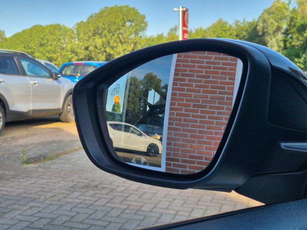 De buitenspiegel van een auto uit de voorraad, met de gevel erin