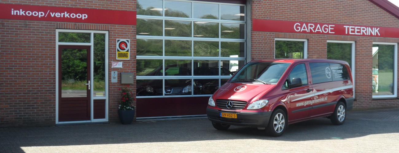 De gevel van Garage Teerink aan de Boeninksteeg in Doetinchem, met de rode bedrijfsbus ervoor